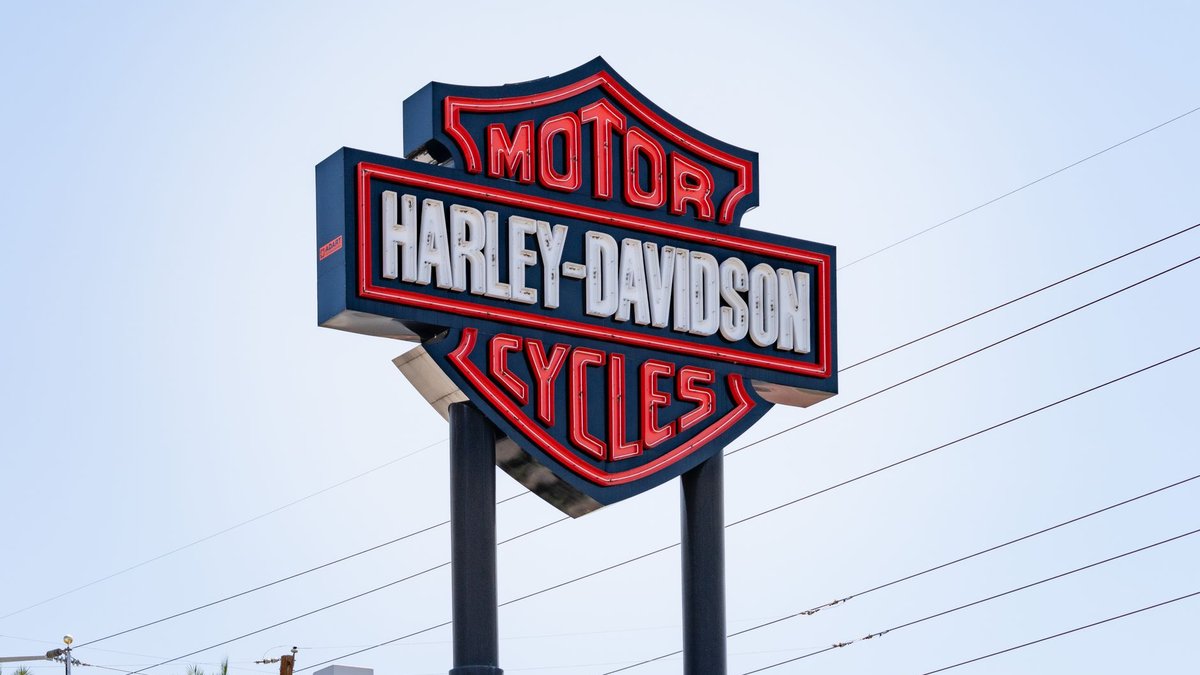 Motorcycle dealership sign against the sky