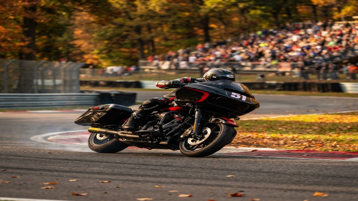 Bagger racing motorcycle braking into a corner at a tree-lined racing circuit during the King of the Baggers finale weekend