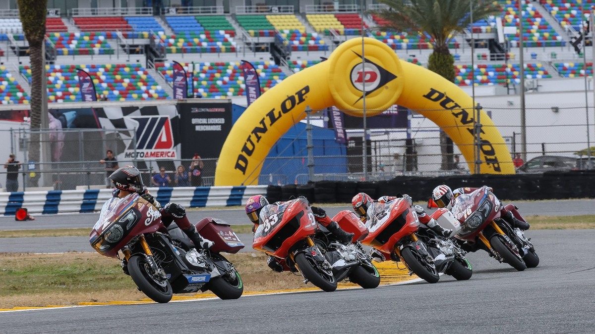 Motorcycle road racers battling through a corner at a race track during a King of the Baggers weekend