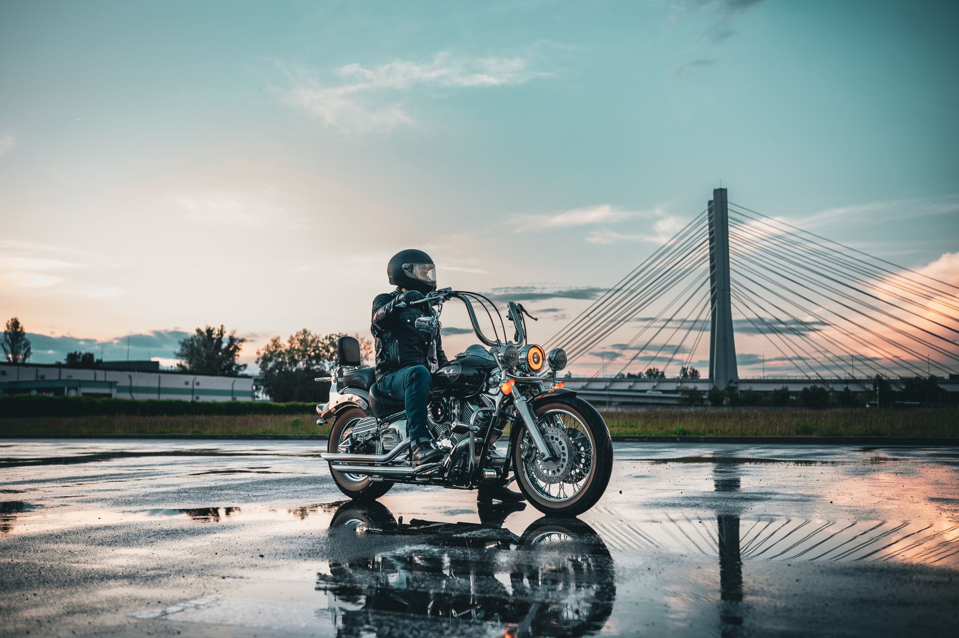 Motorcycle riding safely in heavy rain on a wet highway with proper rain gear