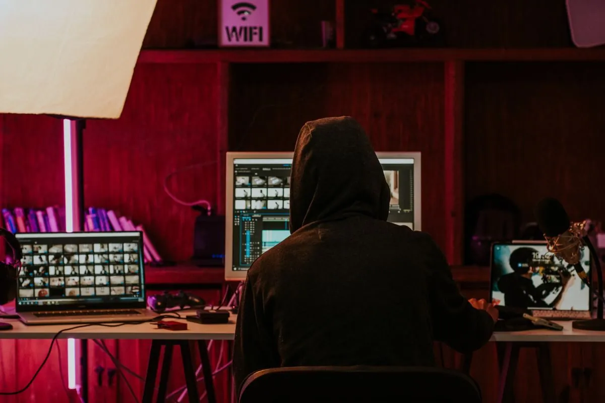 Person editing videos on multiple screens