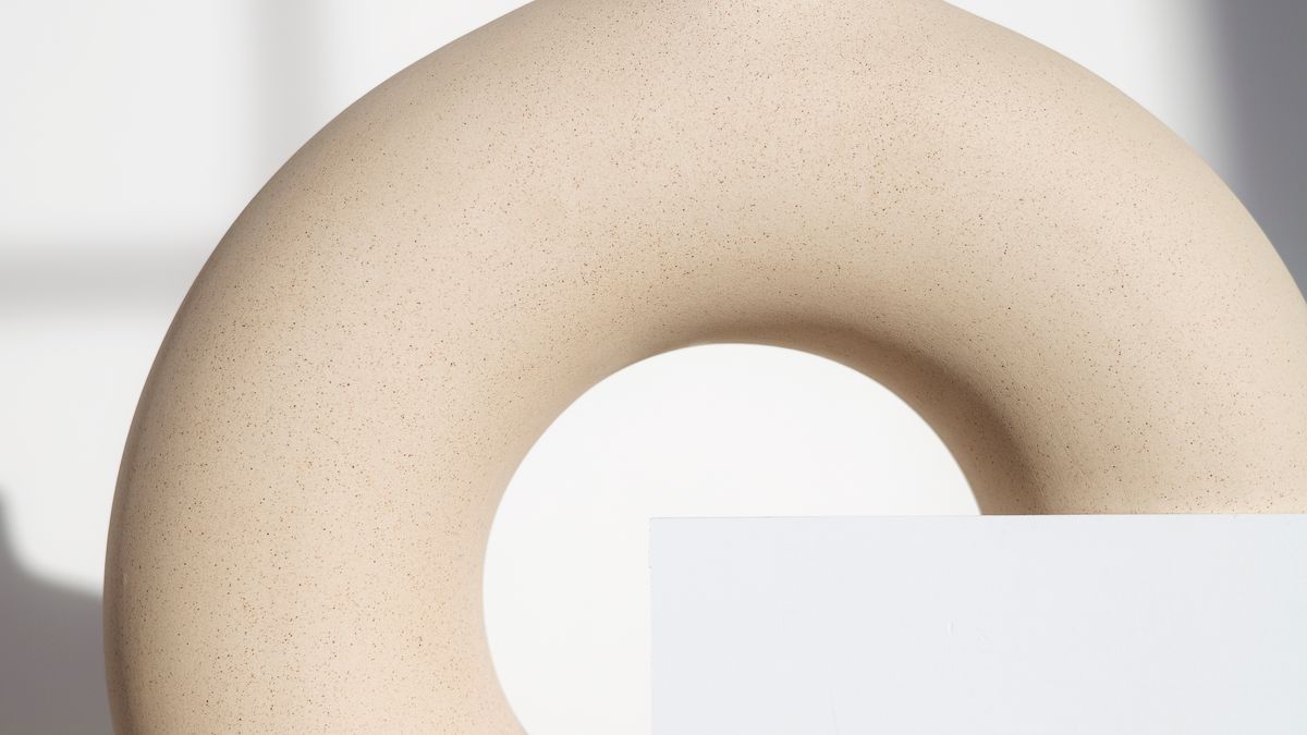 Wireless earbuds on a dark surface representing Apple's upcoming AirPods Pro with infrared cameras for visual intelligence