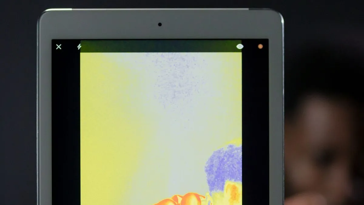 Thermal imaging phone attachment scanning a motorcycle engine block to detect hot spots and failing components