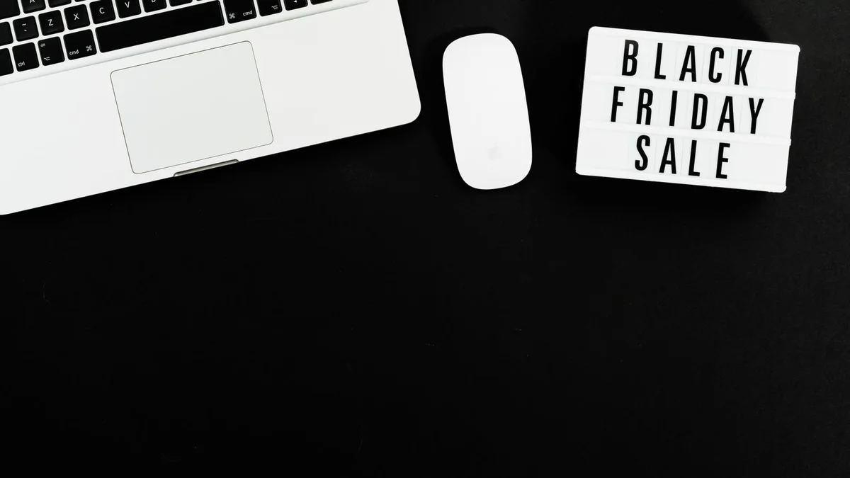Laptop with a Black Friday sale sign on a dark background, representing rising tech prices from US-Canada tariffs in 2026